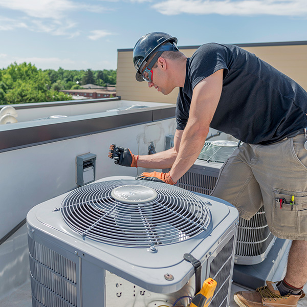 hvac technician repairing a commercial ac unit