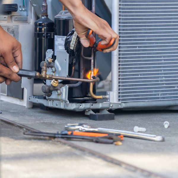 hvac technician fixing AC Unit