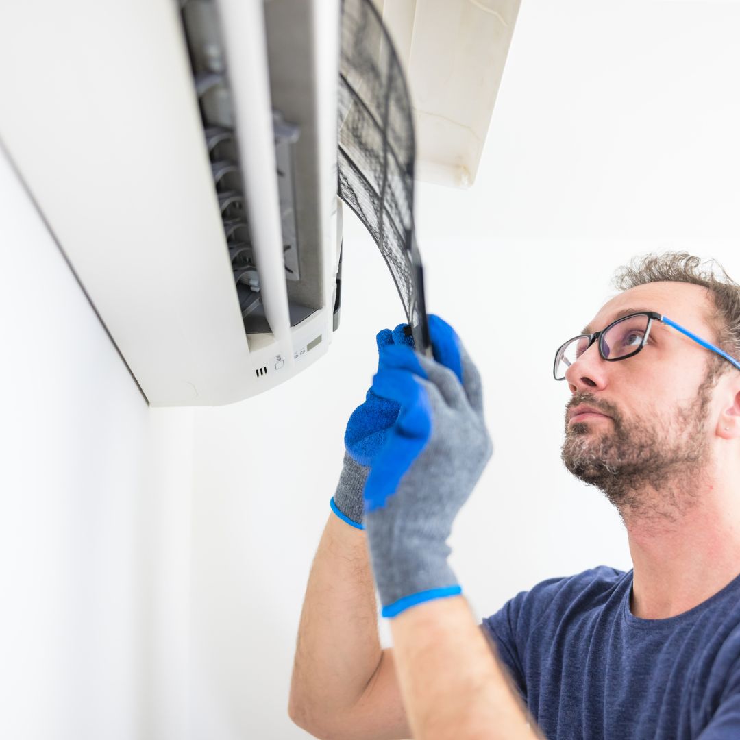 person fixing an AC